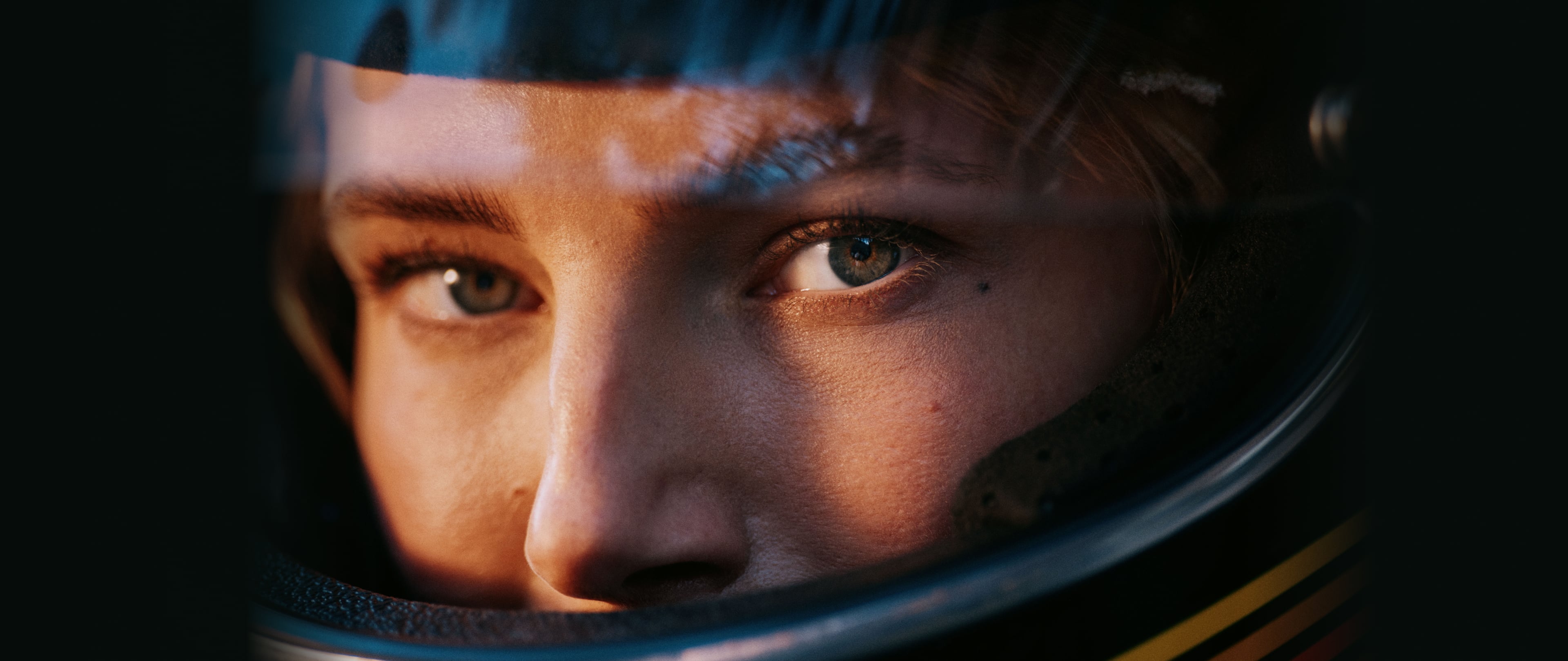 Woman wearing a motorcycle helmet turning towards the camera