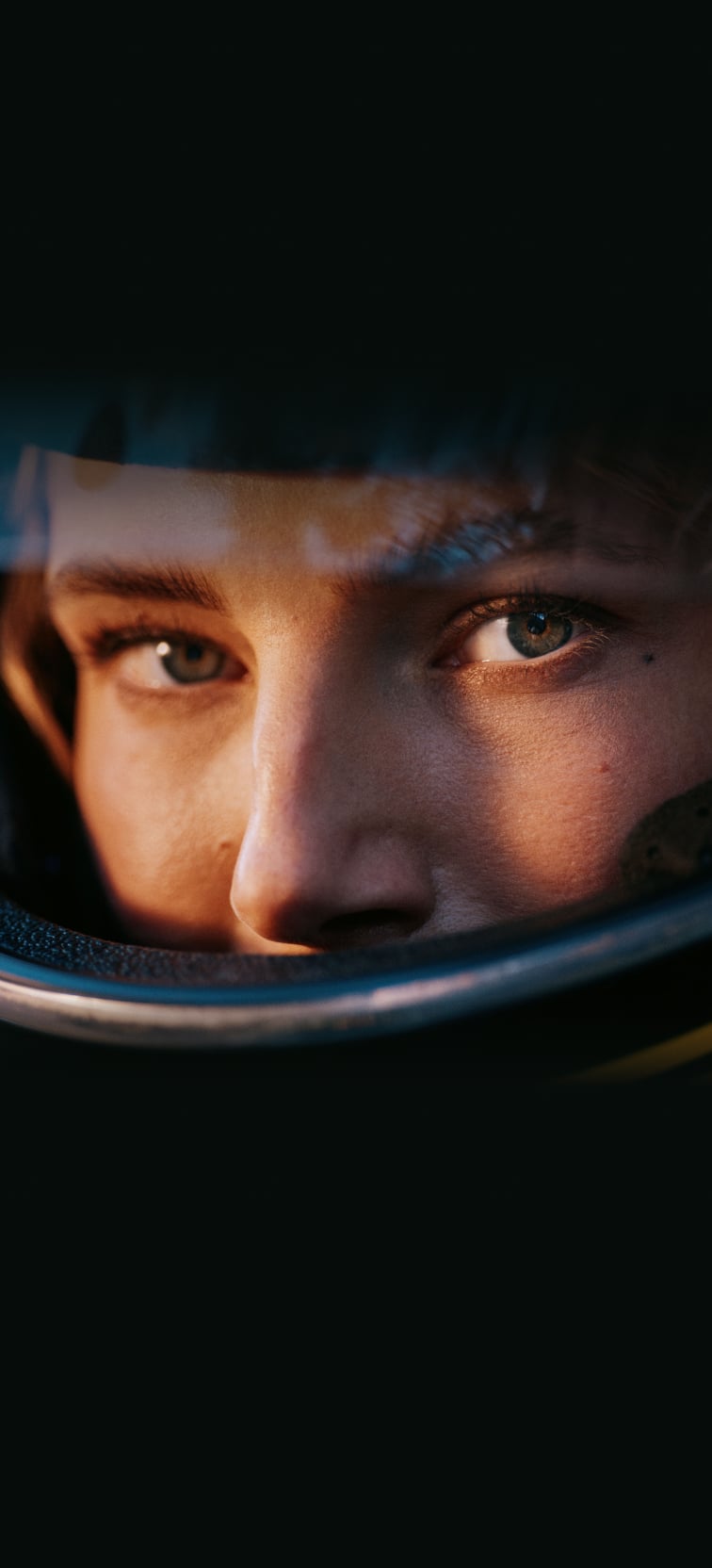 Woman wearing a motorcycle helmet turning towards the camera